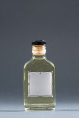 bottle with homemade alcohol tincture or liquor, mockup with empty label, lemon and pineapple