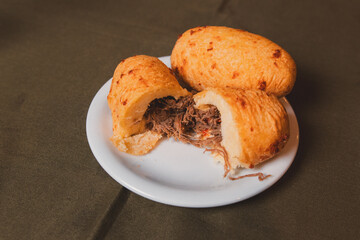 Top view of a cassava bomb stuffed with meat served on a plate.