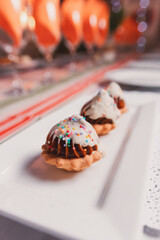 Detail view of small cookies with dulce de leche cream on a small rectangular plate.