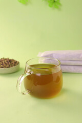 A cup of green tea on a green background 