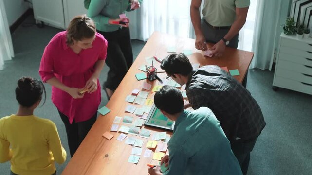 Top view of skilled programmer brainstorming idea about mobile phone interface while develop app development by using wireframe prototype. Web designer planning at table with sticky notes. Symposium.