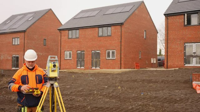 Construction worker surveys new residential development in urban area with advanced equipment 