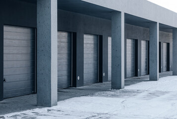 Row of Modern Garage Doors with Concrete Columns in a Snowy Winter Setting