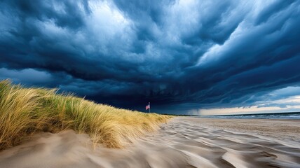 Storm clouds over sandy beach, with flag waving in distance