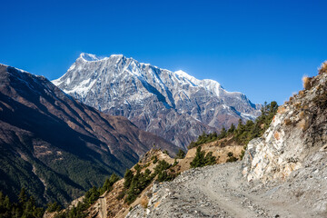 Fototapeta premium A gravel route from Ghyaru to Ngawal against Annapurna III and Gangapurna peaks. Annapurna circuit trek, Himalaya mountains, Nepal.