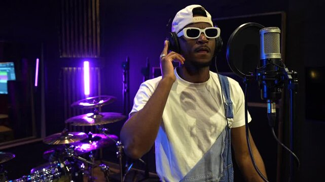Talented african american singer engrossed in recording a song inside a professional music studio