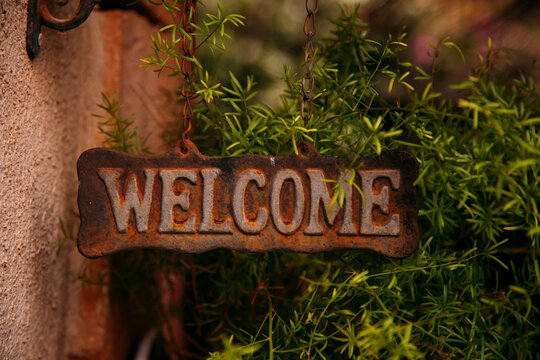 Rusty welcome sign with green plants