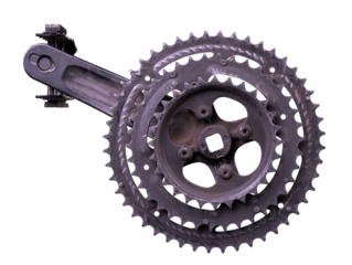 Heavily worn bicycle sprocket and crank on an isolated background.	
