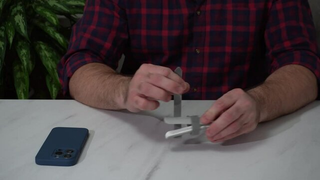 a plastic orthosis, a medical device for fixing a finger after injury. a Velcro bandage in men's hands.