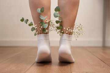 Legs in White Socks with Eucalyptus and Baby’s Breath Flowers