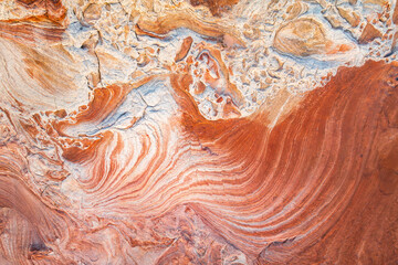 Abstract rock pattern in dynamic red and white swirls.
