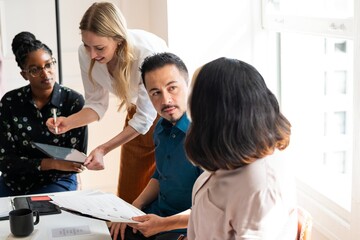 Fototapeta premium A diverse group in a meeting, discussing ideas. Teamwork and collaboration are key. Office setting with diverse professionals sharing insights and strategies. Diverse business meeting in office.
