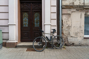 Road bicycle with slim steel frame in front of an old destroyed brick wall next to renovated...