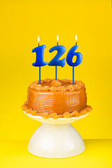 Happy birthday cake with number 126 candle - Card on a yellow background.