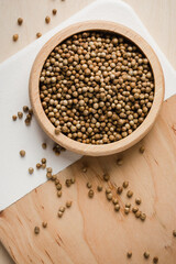 Coriander seeds on wooden table.