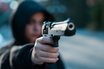 Fototapeta premium Female gangster, gun in hand, threatening, criminal