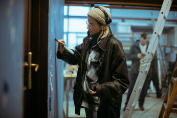 The production designer prepares the scenery on the set. The artist's work in building a frame for filming a movie, advertising, TV series. Modern photography technique.