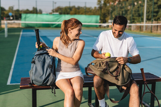 Young couple playing tennis outdoors enjoying a fun summer game