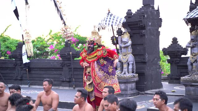 Bali, Indonesia : Dramatic Kecak dance scene with energetic participants and a red-clad character as the focal point in Bali.