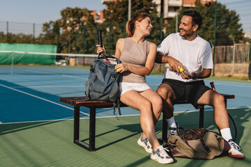 Young couple playing tennis outdoors enjoying a fun summer game