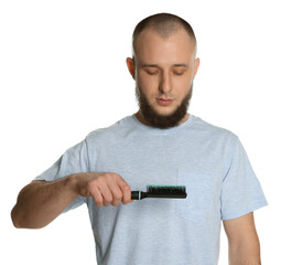 Baldness problem. Man with receding hairline holding brush on white background