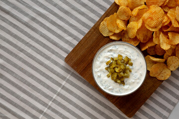 Homemade Creamy Pickle Dip with Potato Chips, top view. Copy space.