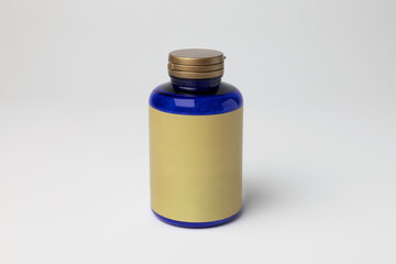 Mockup of a magnesium bottle, food supplement, closed, blue color, with label, on white background with copyspace