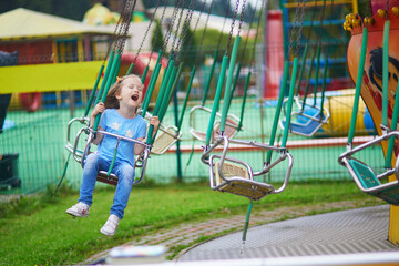 Adorable preschooler girl on traditional merry-go-round in St. Petersburg, Russia. © Ekaterina Pokrovsky
