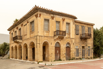 abandoned building with balcony and peeling window shutters in Koroni, Peloponnese, Greece