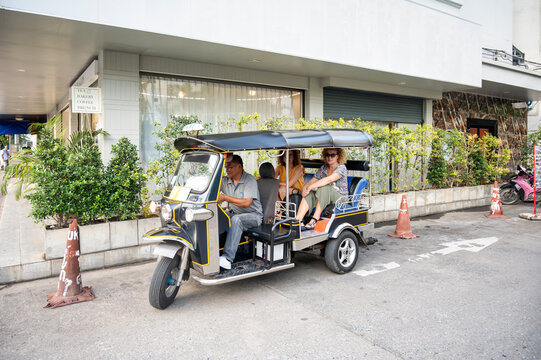 Thai tuk tuk driver transporting tourists in Chiang Rai