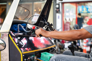 Thai tuk tuk driver steering through Chiang Rai's streets