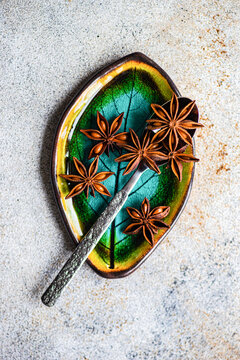 Top view of star anise on a decorative green and yellow dish
