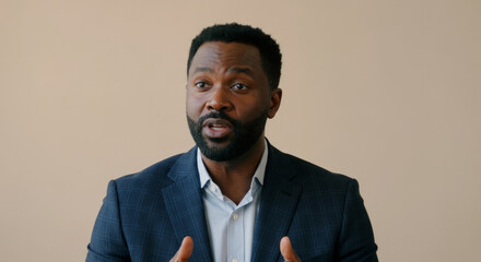 A man in a suit is talking to the camera