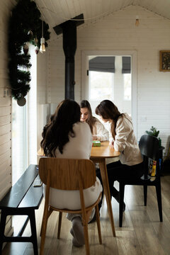 Cozy indoor gathering with young women playing board game