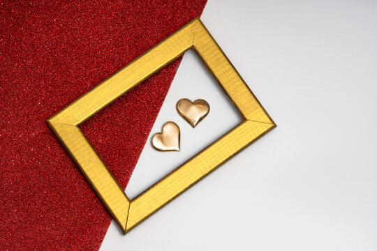 Heart-shaped objects and golden frame on glitter background