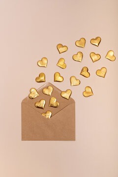 Golden hearts spilling from an envelope on a subtle background