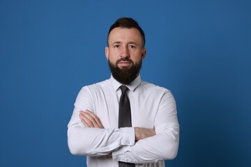 Handsome bearded man in formal outfit on blue background