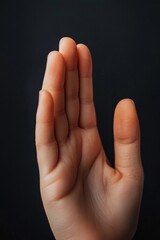 Obraz premium Close-up of a woman's hand against a dark background. Soft lighting, neutral tones.