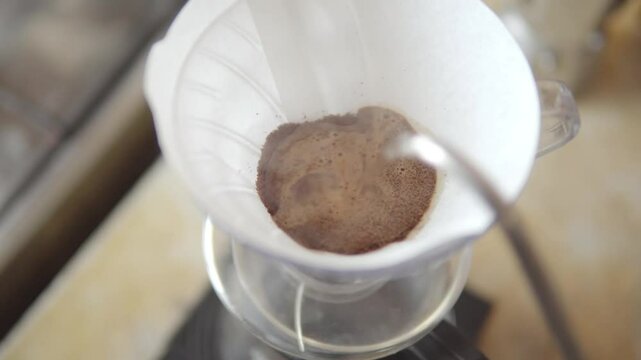 Hot water pouring over coffee grounds in filter