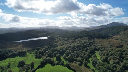 Obraz premium Llyn Geirionydd lies in a valley in North Wales where the northern edge of the Gwydyr Forest meets the lower slopes of the Carneddau mountains. The lake is almost a mile long.