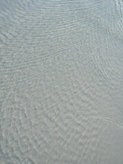 sea moves in calm ripples. On the sandy shore and in the clear sea water.