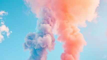 Fototapeta premium A colorful display of smoke billows against a bright blue sky, blending pastel shades of pink and purple, creating a dreamy, ethereal atmosphere.