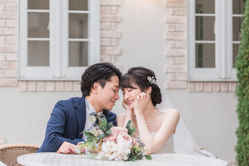 結婚式で結婚式場の庭でブーケと写真を撮る新郎新婦（ガーデンウェディング）
