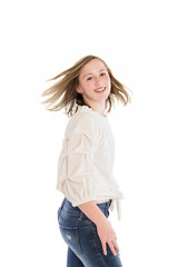 Smiling young teenage teen or tween girl with freckles standing and turning around to face the camera with a hair flip on white background for ad or copy space