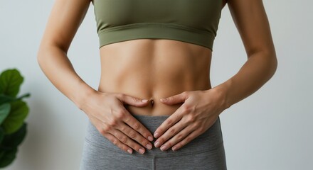 Fitness-focused woman touching her abdominal area, dressed in activewear, representing health and wellness. Encourages a positive lifestyle, healthy living, and body awareness