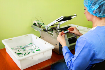 Research assistant sticks labels on bottles of pills. Labeling of medicines on automatic equipment...