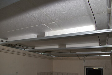 Unterkonstruktion aus Metallprofilen f&uuml;r Gipskartondecke. Dar&uuml;ber Styroporplatten und Dampfsperre.