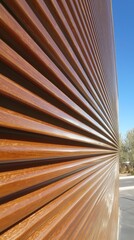 Close-up of a textured wall with horizontal lines against a clear blue sky.