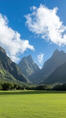 Lush green valley surrounded by majestic mountains under a bright blue sky with clouds.