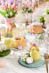 Easter table decoration with spring flowers and cute chicken figurines
